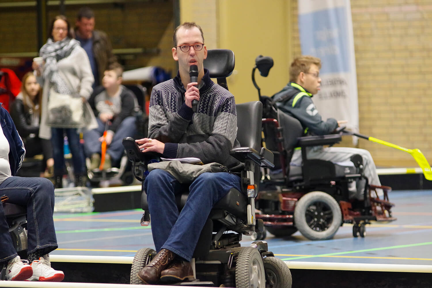 Johannes opent de competitiedag. Hij spreekt door microfoon.