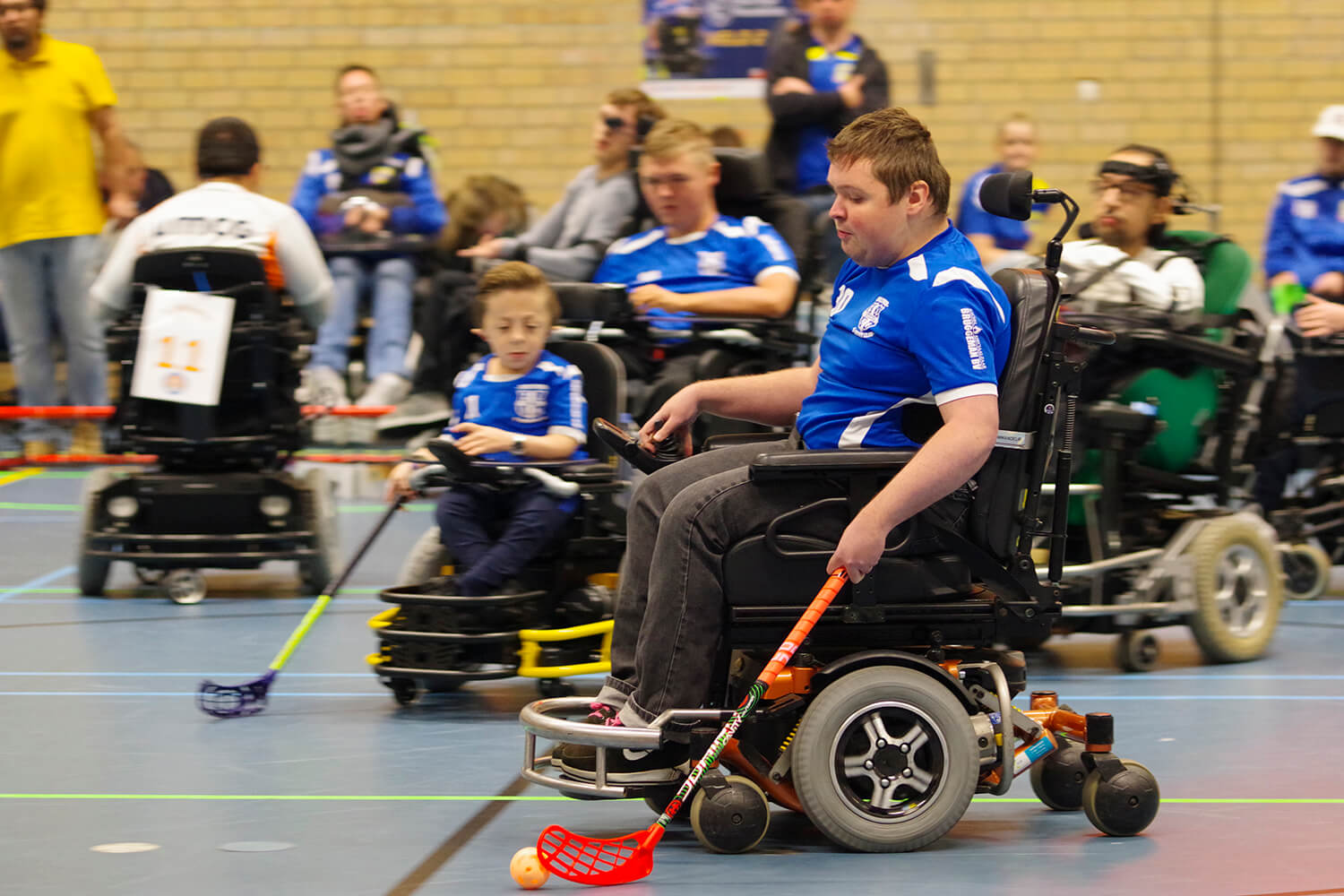 Nico op volle snelheid met hockeybal in stick. Stijn en Maik op achtergrond