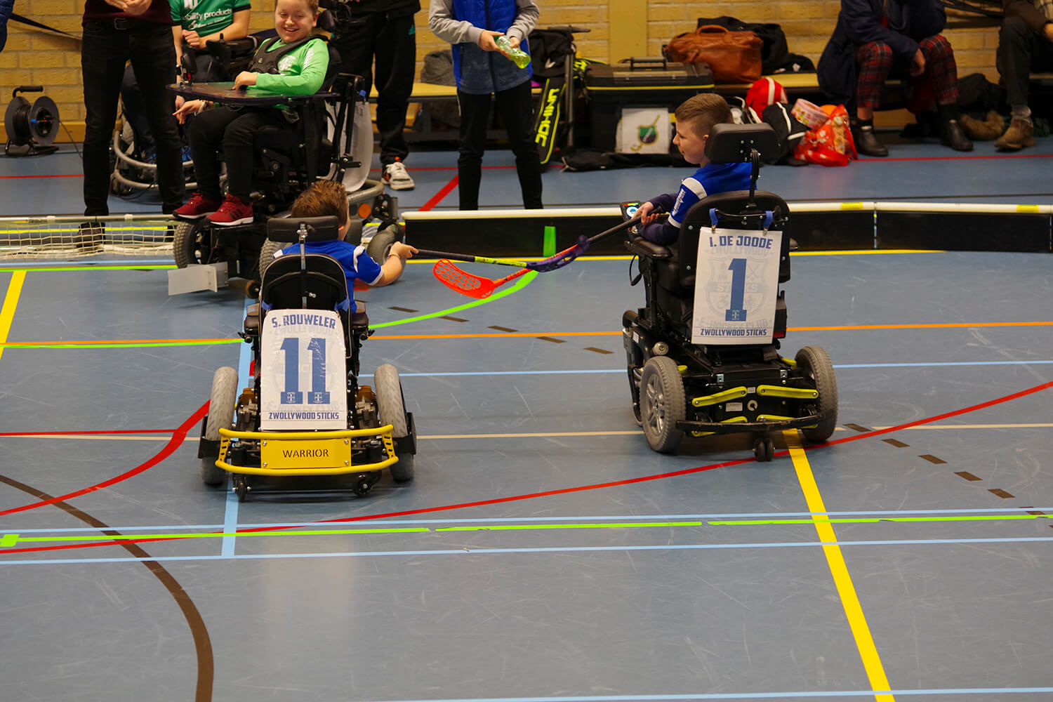 Stijn en Iker raken elkaars stick na goal. Vanaf achterkant gezien.